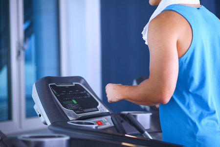 Man at the gym exercising on cross trainersの写真素材