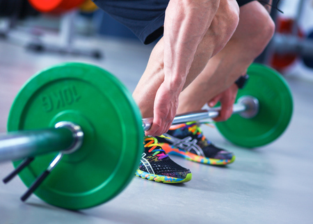 Bodybuilder with barbell in gymの写真素材