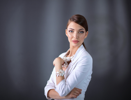 Portrait of young woman with beads, standing on gray backgroundの写真素材