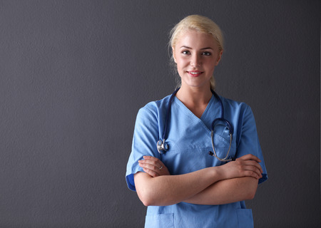 Young doctor woman with stethoscope isolated on gray backgroundの写真素材