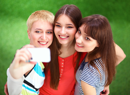 Female friends taking selfie with mobile phoneの写真素材