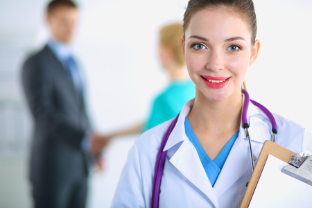 Woman doctor standing with folder at hospitalの写真素材