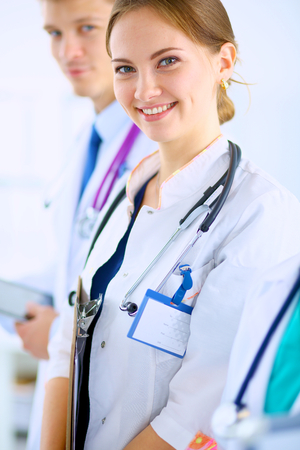 Attractive female doctor  with folder in front of medical groupの写真素材