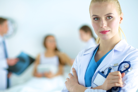 Woman doctor standing with stethoscope at hospitalの写真素材