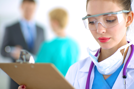 Woman doctor standing with folder at hospitalの写真素材