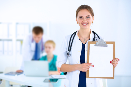 Attractive female doctor  with folder in front of medical groupの写真素材