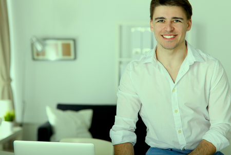 Young businessman working in office, standing near deskの写真素材