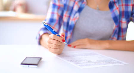 Beautiful young woman writing something in her note padの写真素材