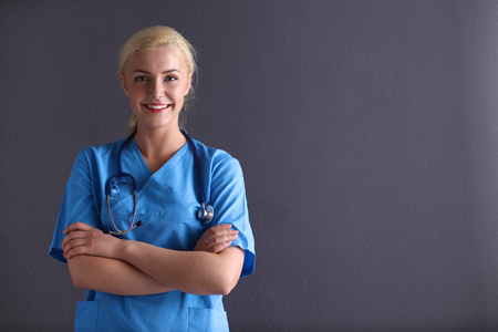 Young doctor woman with stethoscope isolated on gray backgroundの写真素材