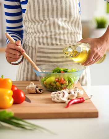 Young woman mixing fresh saladの写真素材