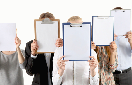 Team of businesspeople holding a folders near face isolated on white backgroundの写真素材