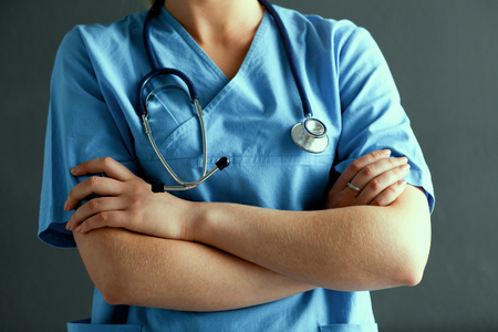 Young doctor woman with stethoscope isolated on gray background.の写真素材