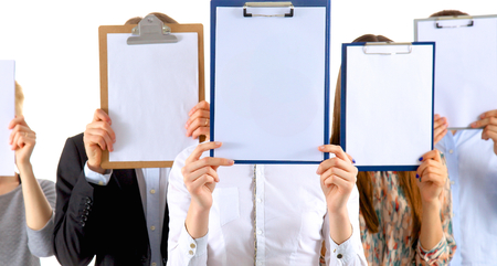 Team of businesspeople holding a folders near face isolated on white background .の写真素材