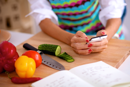 Young woman cutting vegetables in kitchen .の写真素材