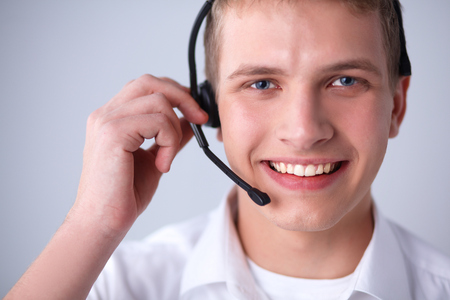 Call center male operator on gray backgroundの写真素材