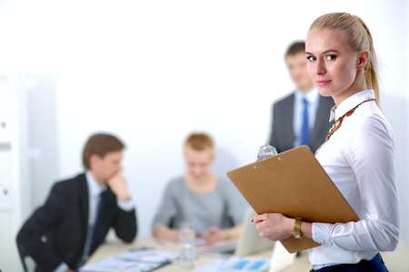 Portrait of a young woman working at office standing with folder .の写真素材