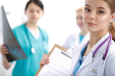 Woman doctor standing with folder at hospital .の写真素材