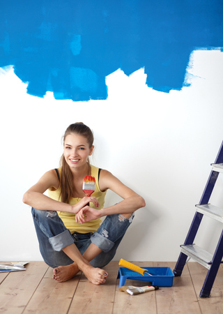 Portrait of female painter sitting on floor after painting.の写真素材