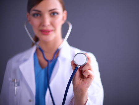 Female doctor with a stethoscope listening, isolated on grey background.の写真素材