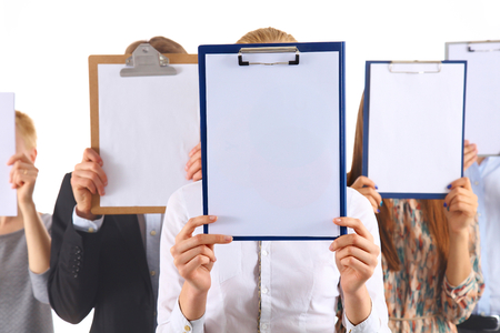Team of businesspeople holding a folders near face isolated on white background .の写真素材