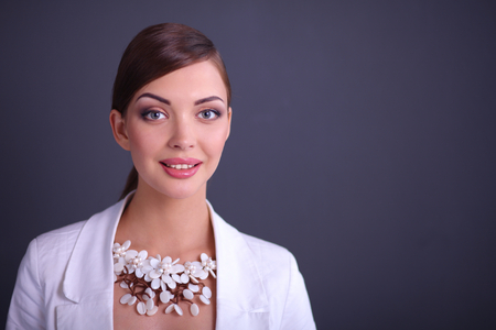 Portrait of pretty young woman with beads, isolated on gray backgroundの写真素材