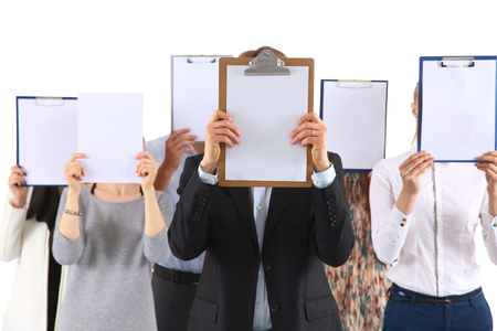 Team of businesspeople holding a folders near face isolated on white background .の写真素材