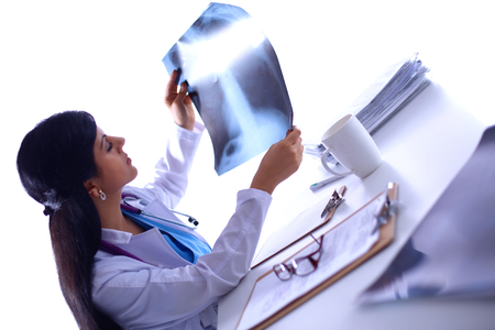 Young female doctor studying x-ray image, sittingの写真素材
