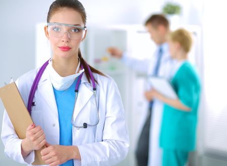 Woman doctor standing with folder at hospital .の写真素材