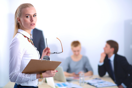 Portrait of a young woman working at office standing with folder .の写真素材