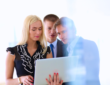 Business woman standing with her staff in background at modern office .の写真素材