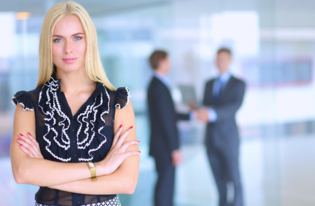 Business woman standing in foreground in office .の写真素材