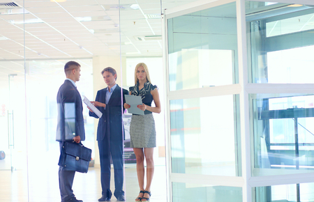 Business woman standing with her staff in background at modern office .の写真素材