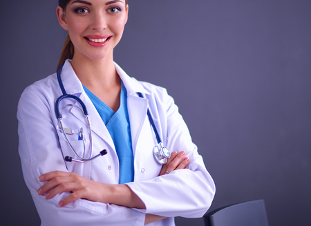 Young doctor woman with stethoscope isolated on grey backgroundの写真素材