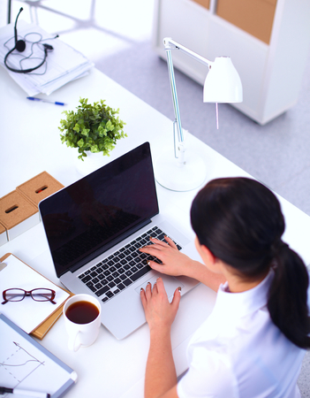 Attractive businesswoman sitting  in the office, isolatedの写真素材