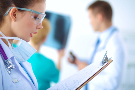 Woman doctor standing with folder at hospital .の写真素材