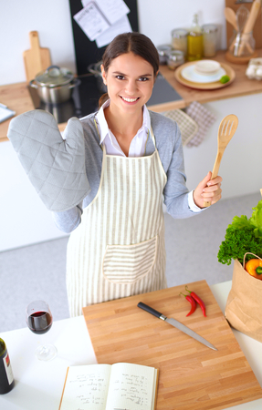 Woman making healthy food standing happy smiling in kitchenの写真素材