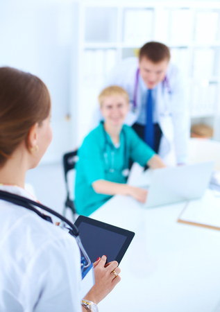Beautiful young smiling female doctor sitting at the desk .の写真素材
