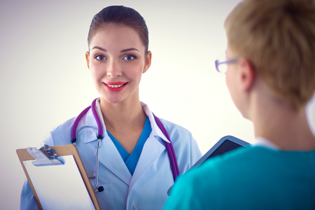 Portrait of a doctor with her colleague standing back to us in front of herの写真素材