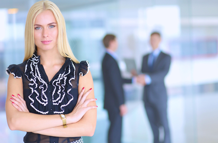 Business woman standing in foreground in office .の写真素材
