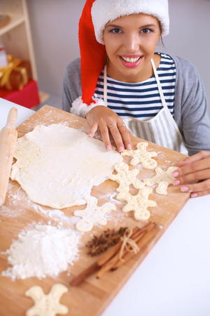 Woman making christmas cookiesin the kitchen, isolatedの写真素材