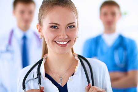 Attractive female doctor in front of medical group .