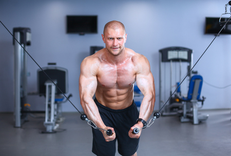 Young man training at gym with exercises .の写真素材