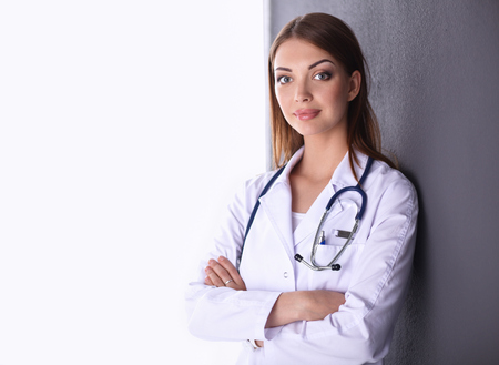 Young doctor woman with stethoscope isolated on grey backgroundの写真素材
