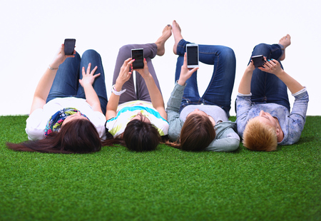 Four young women lying on green grass  .の写真素材