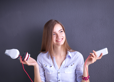 Portrait of smiling girl with headphones , isolated on grey backgroundの写真素材