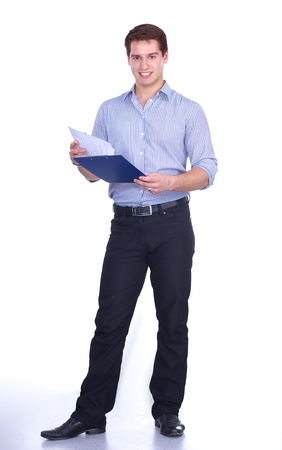 Portrait of young man standing with folder, isolated on white backgroundの写真素材
