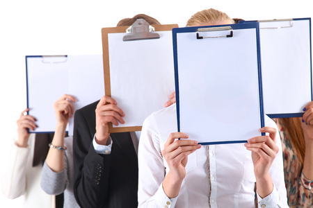 Team of businesspeople holding a folders near face isolated on white background .の写真素材