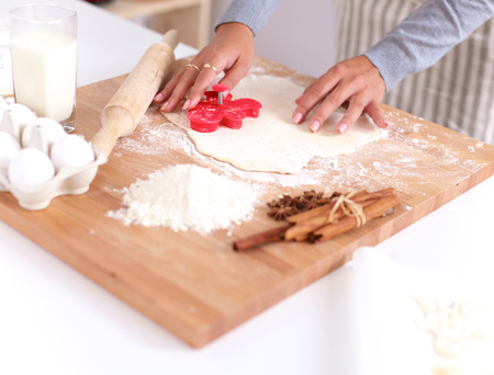 Woman making christmas cookiesin the kitchen, isolatedの写真素材