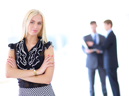 Business woman standing in foreground in office .の写真素材