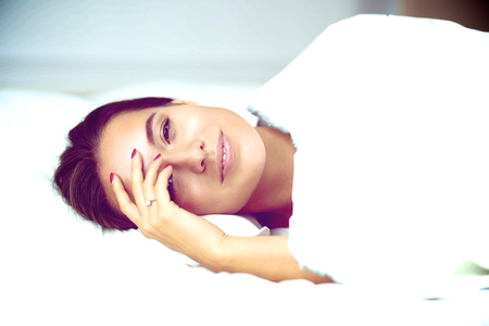 Young beautiful woman lying in bed.の写真素材